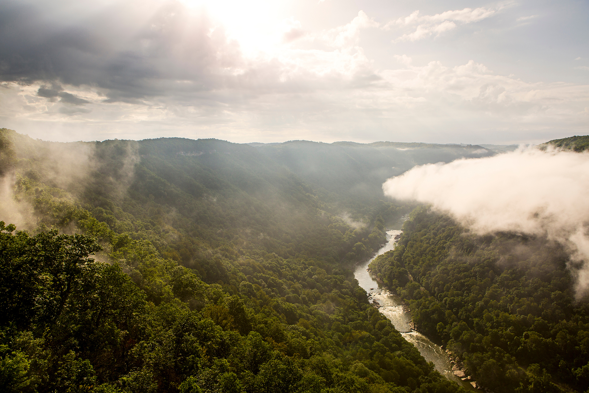 The sun rises over the New River Gorge on a misty, rainy morning in West Virginia