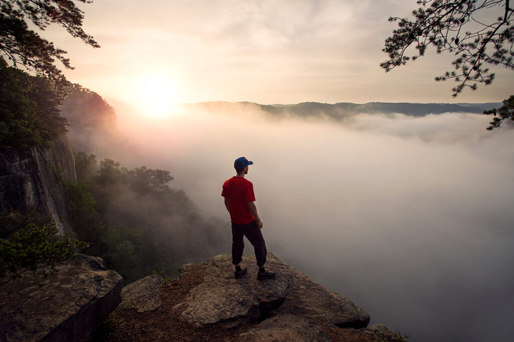 Rainy day activities in New River Gorge looking over the Endless Wall trail in West Virginia on a misty morning at sunrise