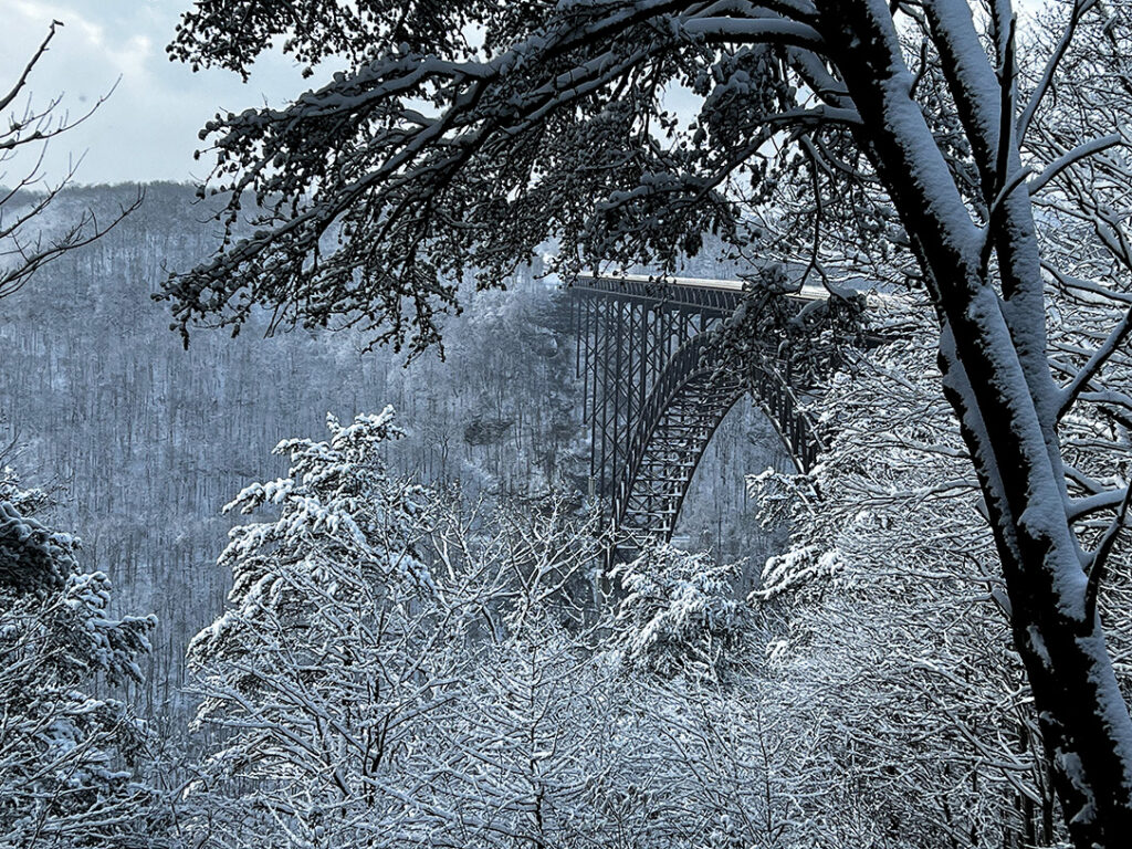 Winter in New River Gorge National Park Snowy Peak of New River Gorge Bridge surrounded by snowy trees