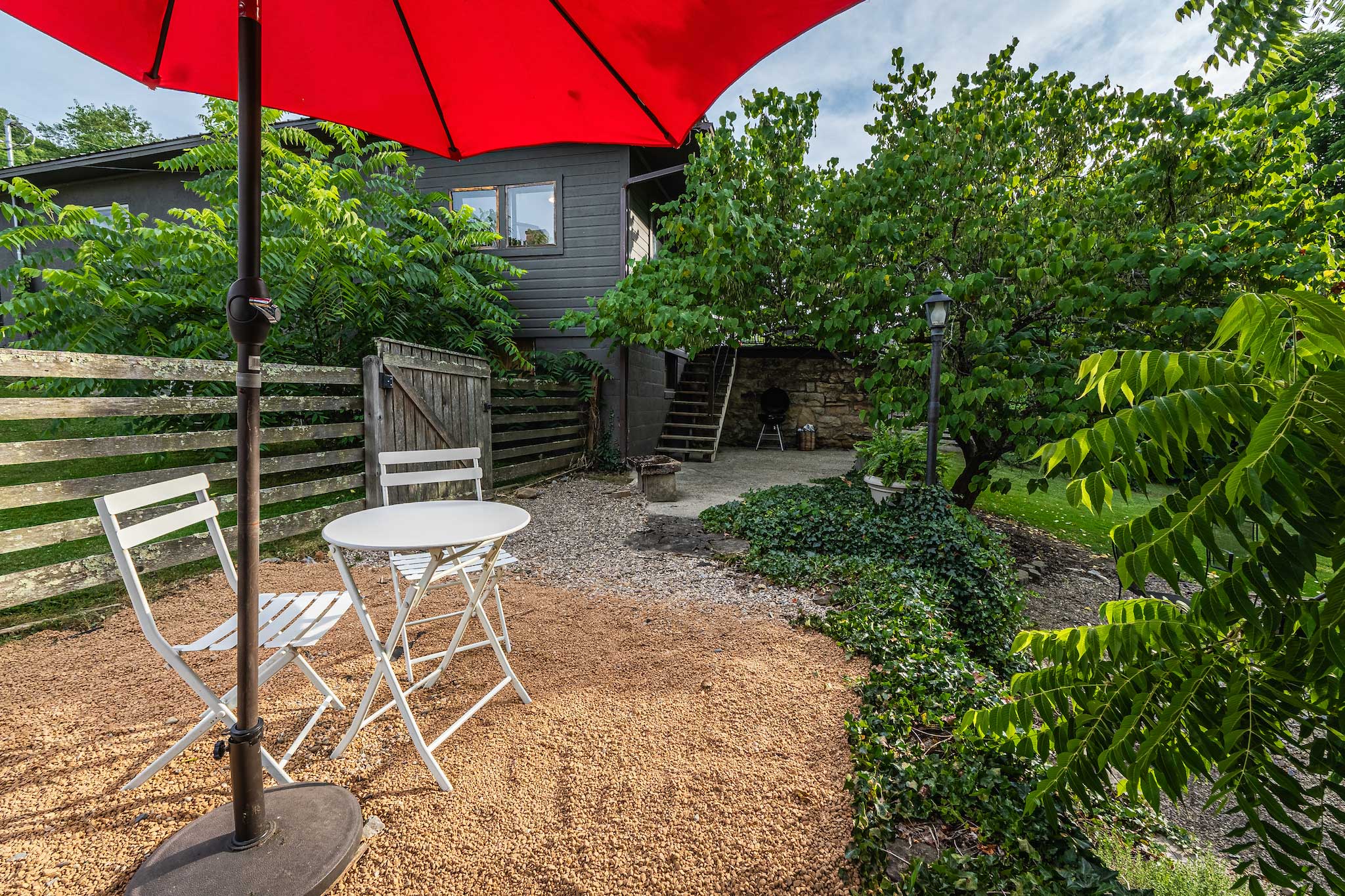 Back patio with red umbrella and bistro chairs