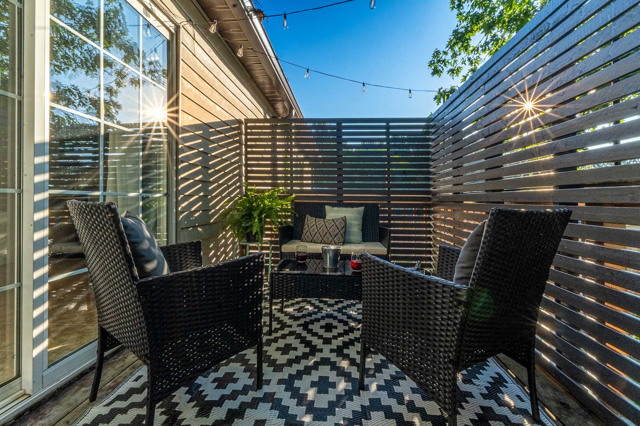 Private enclosed deck with rattan seating and string lights at Gorge Getaway