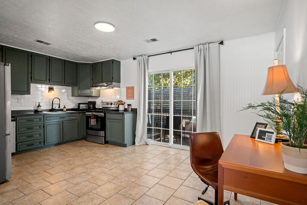 Gorge Getaway kitchen with green cabinets, subway tile backsplash, and stainless appliances