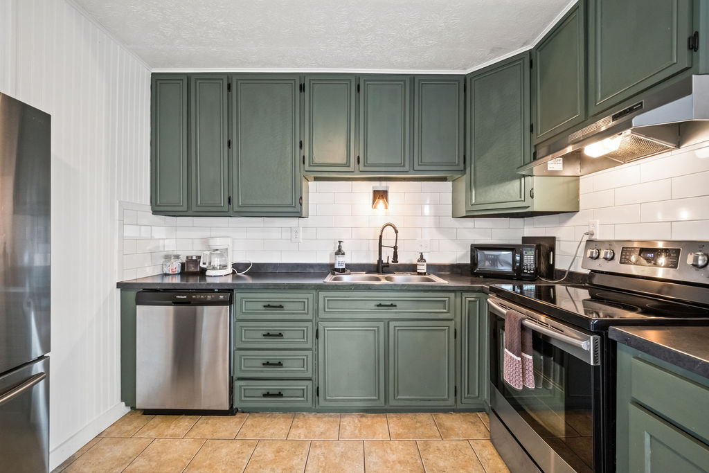 Kitchen with teal cabinets and subway tile backsplash at Gorge Getaway Oak Hill WV